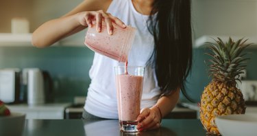 Woman preparing fresh fruit smoothie, as an example of foods to eat when nauseated