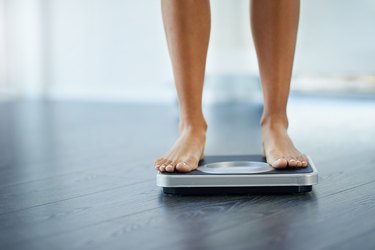 View of a woman's bare feet on a black bathroom scale