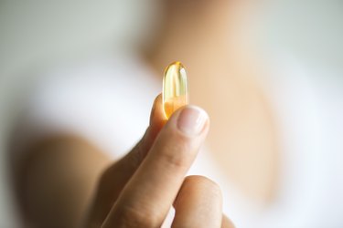 Woman Holding And Showing Omega 3 Capsule