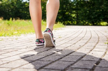 Low Section Of Woman On Footpath In Park