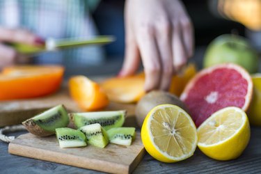 Close view of a person's hands cutting citrus fruit, as a natural remedy for canker sores