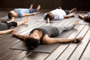 Group of sporty people in Savasana pose