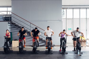 People in gym using exercise bikes