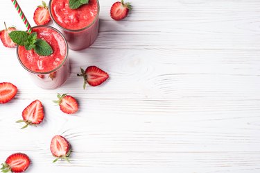 Strawberry smoothie in glass on white background with copy space. Summer drink cocktail. Healthy eating dieting and breakfast concept