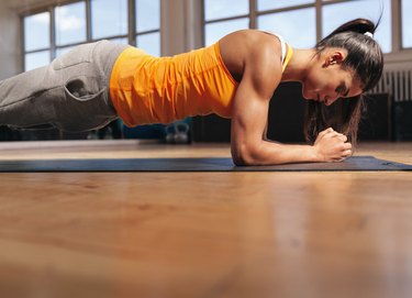 Muscular female doing core workout in the gym