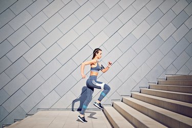 Girl is running on the city stairs and listening the music