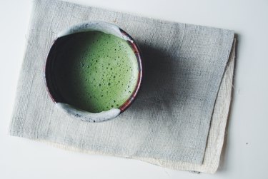 Bowl of Matcha green tea prepared in traditional ceremonial manner, high angle view.