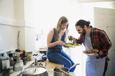 Couple cooking together at home to cut calories