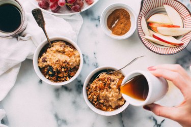 hand pouring coffee into oatmeal