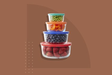 A stack of four Pyrex containers storing different fruit and vegetables