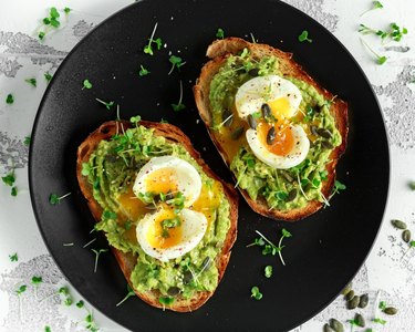 Avocado toast topped with soft boiled eggs