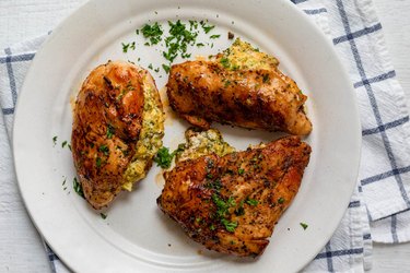 Broccoli and cheese stuffed chicken, plated with green herbs