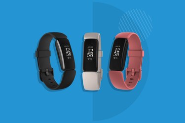 Three FitBit trackers against a blue background
