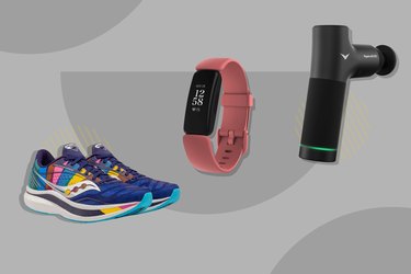 Running shoes, FitBit and Hyperice massage tool on a grey background