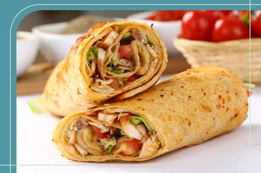 Healthy chicken and vegetable wrap on a table, cut into halves