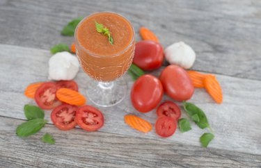 Anti-inflammatory Drink Savory Tomato, Basil and Carrot Smoothie in a glass with tomato and carrot slices