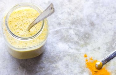 Anti-inflammatory drink Turmeric Citrus Sunshine Smoothie in a mason jar with a spoon