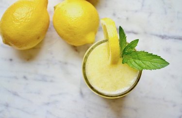 Whole Lemon Spritzer in glass cup on marble table
