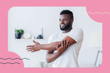 person with a beard doing upper body stretch at home to ease muscle soreness from 30-day push-up challenge