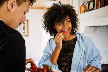 man and woman eating strawberries