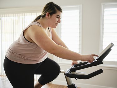 Person in workout clothing using an exercise bike at home