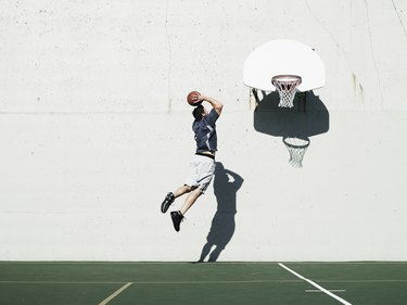 mid-air view of man dunking a basketball after learning how to increase your vertical jump