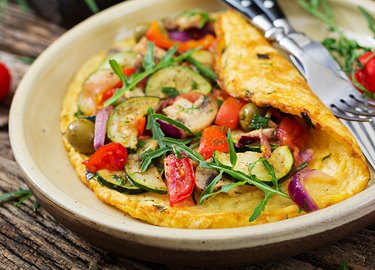 Omelet with tomatoes, zucchini and mushrooms. Omelette breakfast. Healthy food.