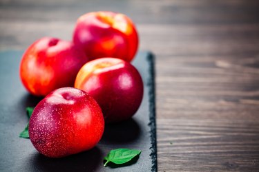 Peaches with vitamin b17 in pits on black stone plate