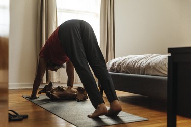Mature man in his bedroom doing a yoga pose for bladder control