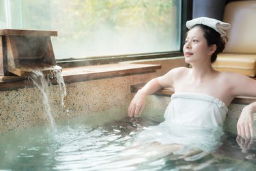 Asian woman enjoying a hot bath in a towel