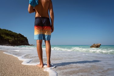 Young man on the rocks by the beach wearing underwear Stock Photo