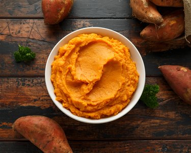 Carbohydrate-rich mashed sweet potatoes on wooden table