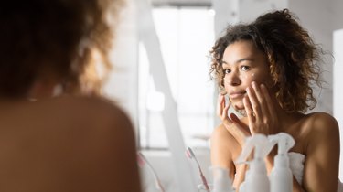 A woman applying eye cream with hyaluronic acid