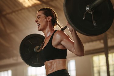 Strong woman exercising with heavy weights