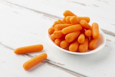 Small bowl filled with low-calorie manufactured baby carrots for good nutrition.