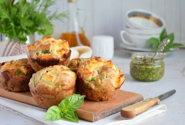 Freshly baked muffins with spinach, sweet potatoes and feta cheese on white background. Healthy food concept. Savory pastry.