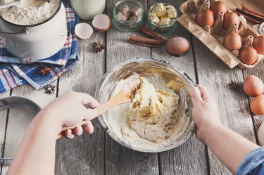 hands mixing ingredients for baking, eggs and flour, two major food allergens