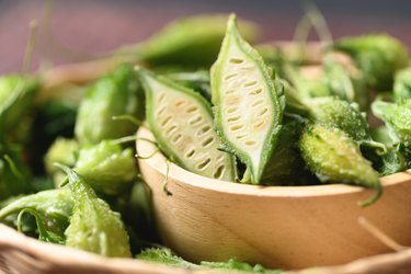 Organic l-citrulline-rich bitter melon, sliced in a wooden bowl.