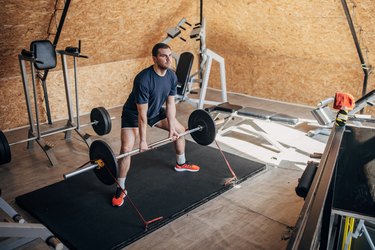 Person performing deadlift in gym to improve muscular endurance.