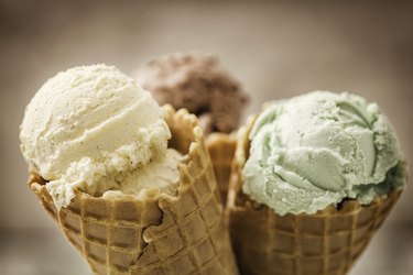 Vanilla, Chocolate and Pistachio Ice Cream, a food that can cause stomach pain, in cones with a brown background