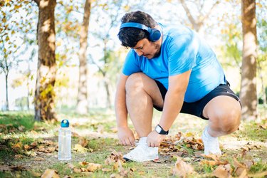 Person tying shoe laces before running outside to avoid shin splints