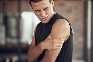 Athlete holding triceps in pain.