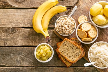 Bananas, toast, rice and crackers displayed on a wooden background