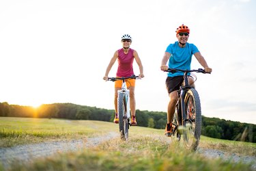 two adults cycling on a dirt path