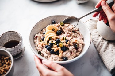 Woman making healthy breakfast with high fiber foods, as a way to treat a weak pelvic floor