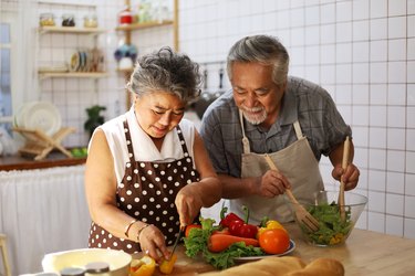 Older couple preparing a healthy meal together in kitchen