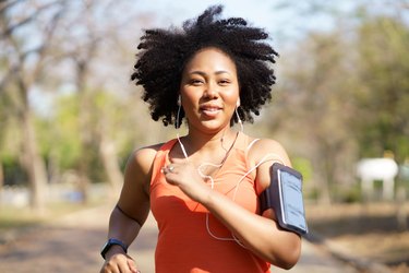Person in orange tank top running, exercising during their period