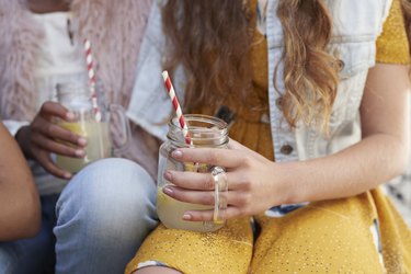 Girls sitting on staircase & drinking lemonade