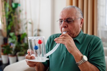 man with copd using an incentive spirometer