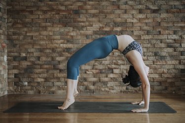a yoga instructor performing wheel pose, one of the worst yoga poses for beginners